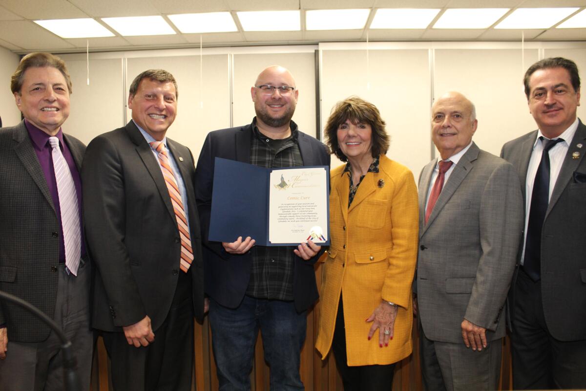 Joining comic Richy Leis holding his mayor’s commendation are Glendale City Council members, from left, Vrej Agajanian, Mayor Ara Najarian, Paula Devine, Frank Quintero and Vartan Gharpetian.