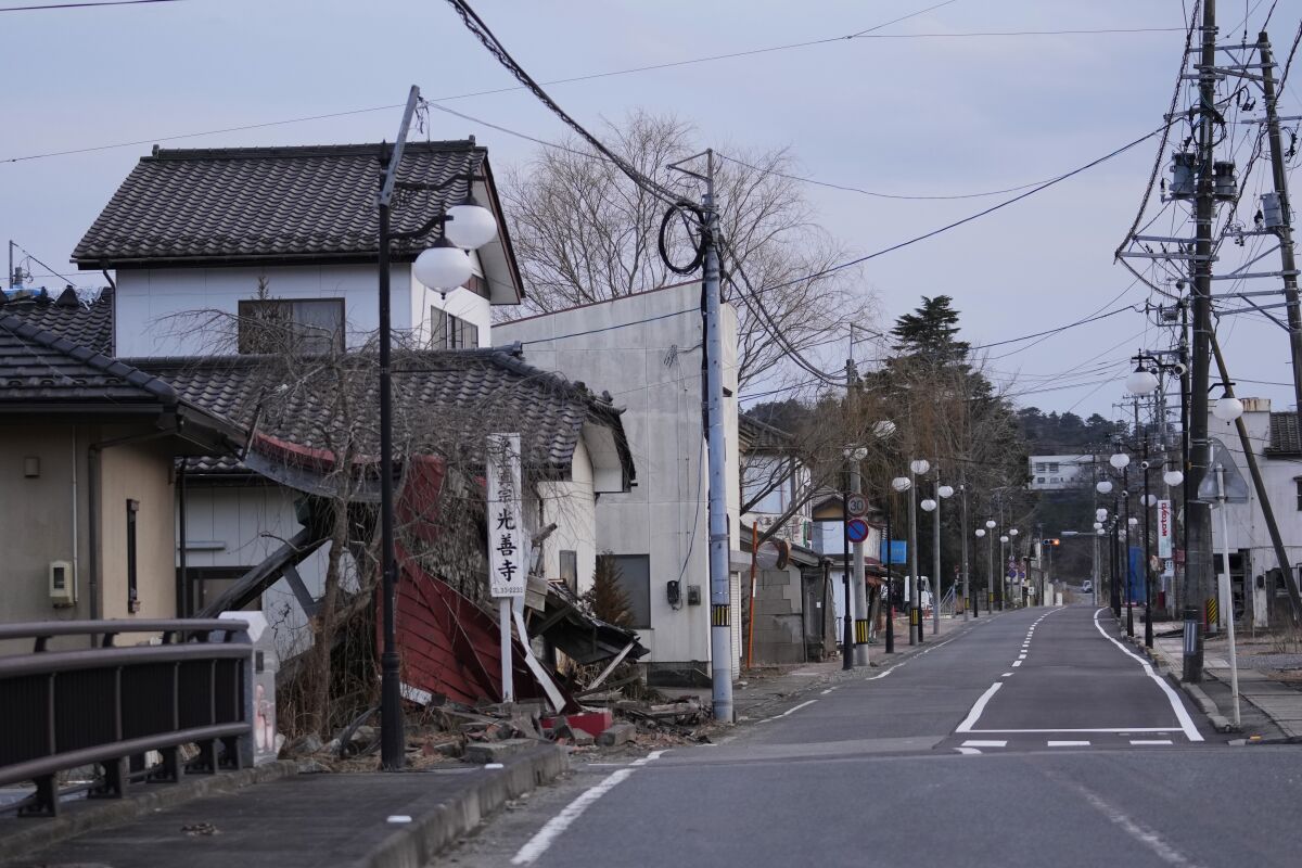 A damaged gate of a Buddhist temple is seen untouched on an empty street in Futaba, northeastern Japan, Tuesday, March 1, 2022. Until recently, Futaba, home to the Fukushima Daiichi nuclear plant, has been entirely empty of residents since the March 2011, disaster. (AP Photo/Hiro Komae)