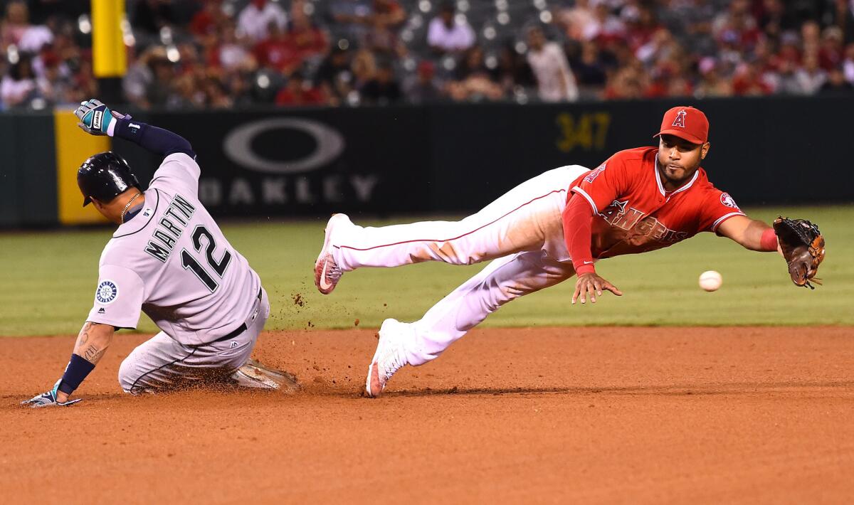 Angels infielder Gregorio Petit reaches for a wide throw as Mariners outfielder Leonys Martin (12) slides in safelly with a stolen base in the fourth inning.