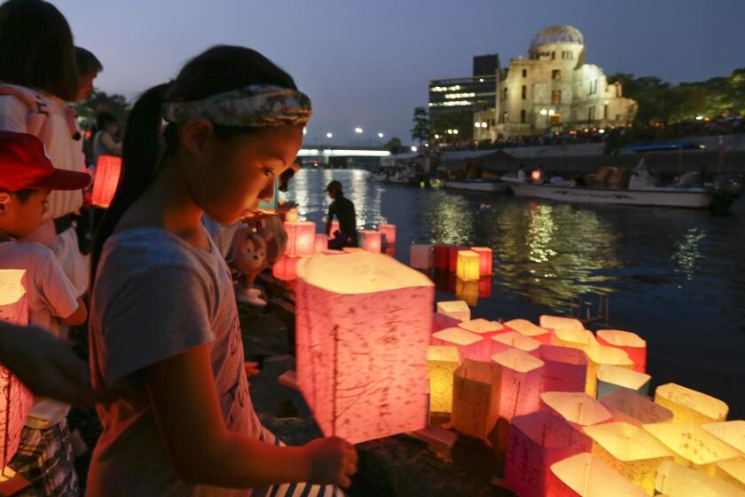 A girl floats a paper lantern on the Motoyasu River to comfort souls of victims killed by the atomic bombing at Hiroshima.