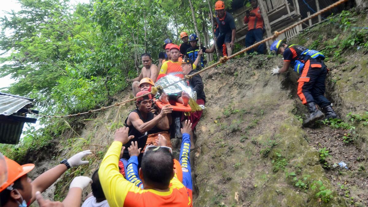A resident is rescued from the landslide in Naga on the Philippines island of Cebu.