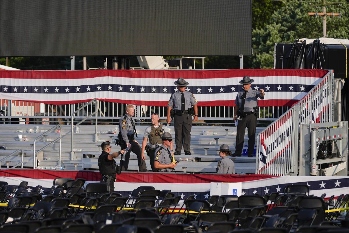 Law enforcement officers gather at an emptied campaign rally site for former President Trump.