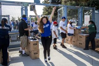 LOS ANGELES, CA - JUNE 15, 2021: Alice Maldonado of Los Angeles reacts as she enter Dodgers Stadium for its reopening night holding a bobble head of Justin Turner before the Dodgers play the Phillies on June 15, 2021 in Los Angeles, California.(Gina Ferazzi / Los Angeles Times)