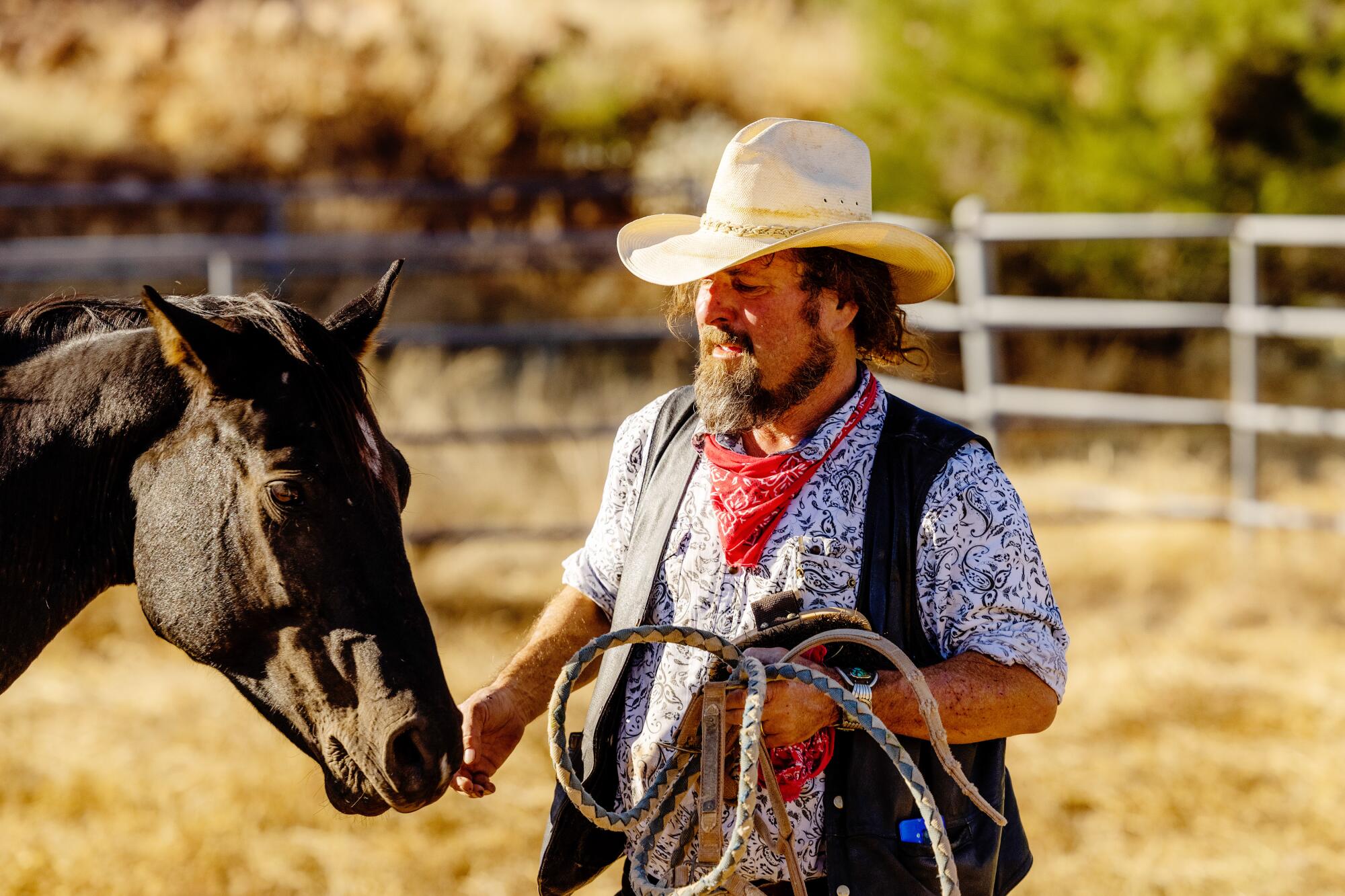 Langdon Hill tends to a mustang, Rosie, on his cattle ranch in Arizona.