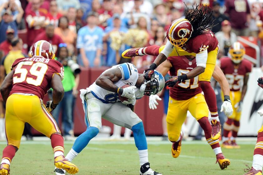 Washington Redskins free safety Brandon Meriweather, top, tries to pull down Detroit Lions wide receiver Calvin Johnson during a game in September. Meriweather was suspended by the NFL on Monday.
