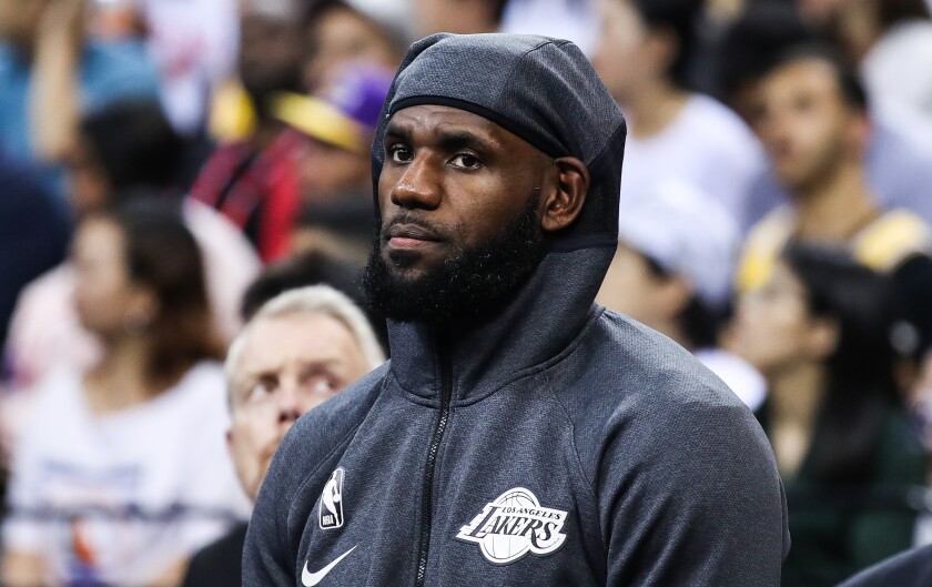 LeBron James watches from the sideline during an exhibition game in China against the Brooklyn Nets.