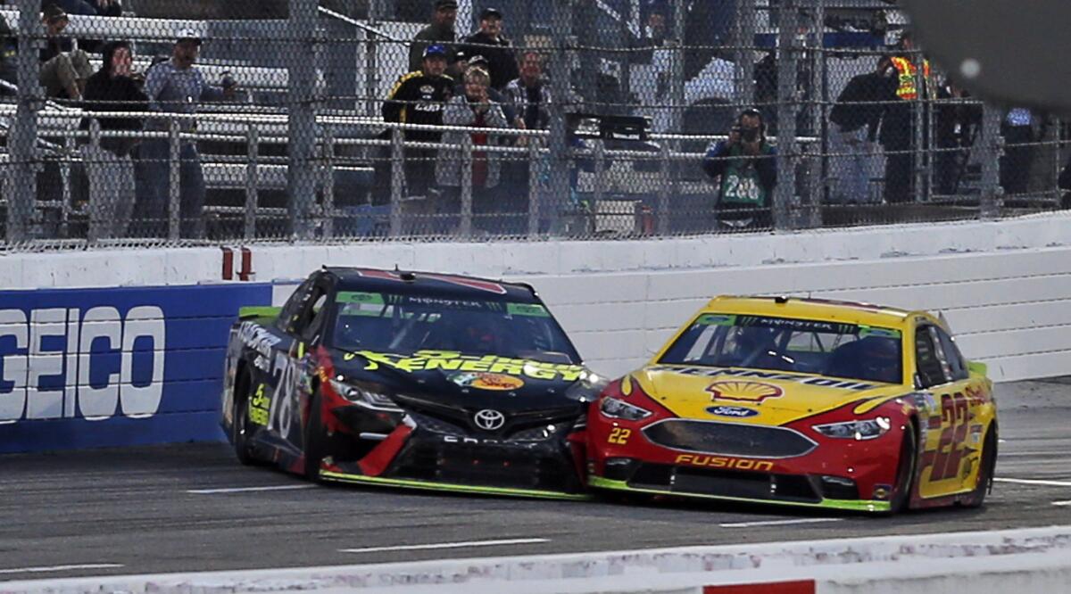 The cars of NASCAR drivers Joey Logano (22) and Martin Truex Jr. (78) make contact near the finish line at the Monster Energy NASCAR Cup Series race at Martinsville Speedway on Sunday.