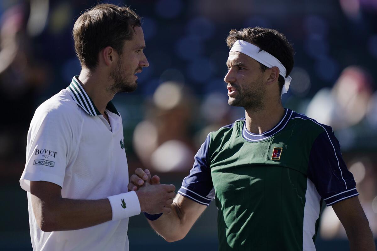 Grigor Dimitrov shakes hands with Daniil Medvedev after their match.