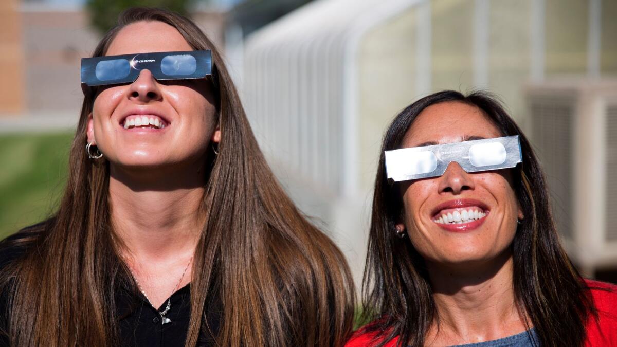 Two science teachers in the Twin Falls, Idaho, school district -- which bought 11,000 pairs of solar glasses for viewing the Aug. 21 eclipse -- use their shades to look at the sun on July 18.