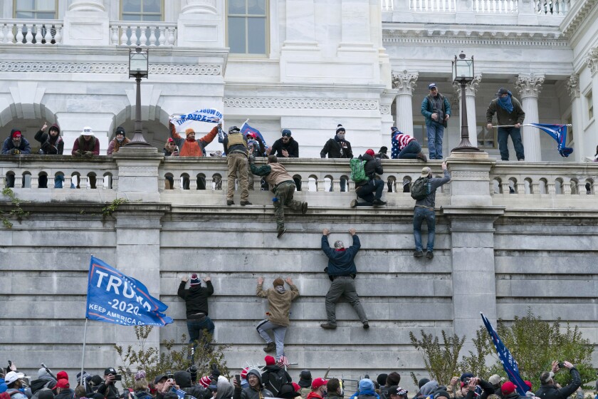 FILE - In this Jan. 6, 2021 file photo, violent insurrectionists loyal to President Donald Trump scale the west wall of the the U.S. Capitol in Washington. Many of those who stormed the Capitol on Jan. 6 cited falsehoods about the election, and now some of them are hoping their gullibility helps them in court. Attorneys for several defendants facing charges connected to the deadly insurrection say they will raise their client's belief in conspiracy theories and misinformation, either as an explanation for why they did what they did, or as an attempt to create a little sympathy. (AP Photo/Jose Luis Magana, File)