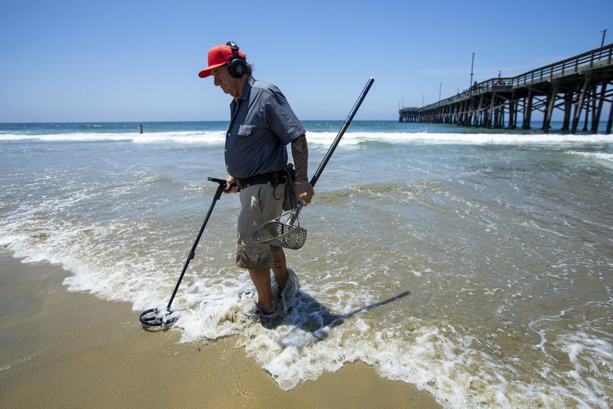 Stan Ross, 79, searches for metal near the Newport Beach Pier on Wednesday.