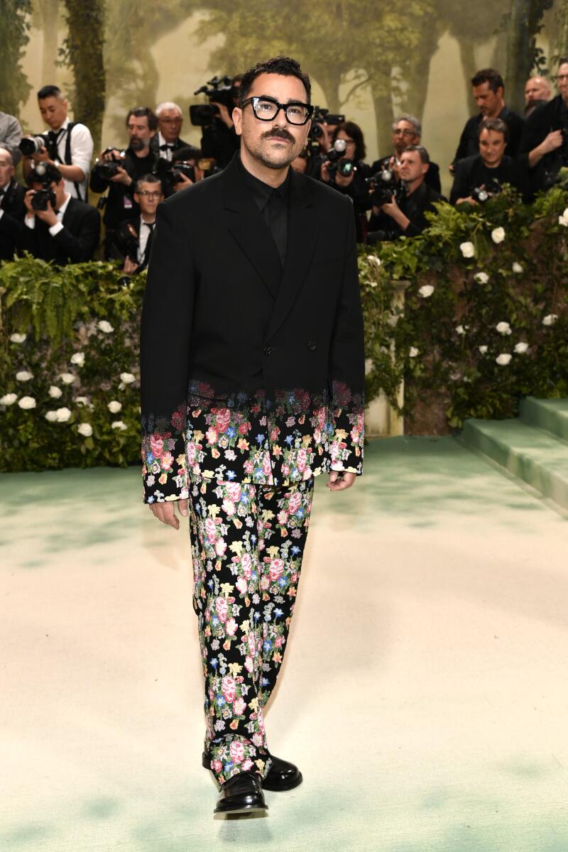Dan Levy, who is always good for some levity, wears a Loewe ensemble that flows from serious, solid black on top to all-over fun floral toward the jacket’s hem and along the trousers.