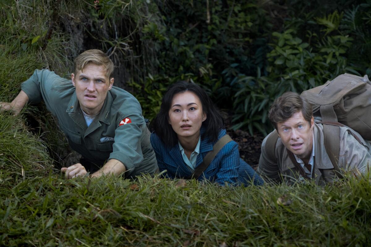 Lee, Keiko and Bill lay crouched in a hillside trench.