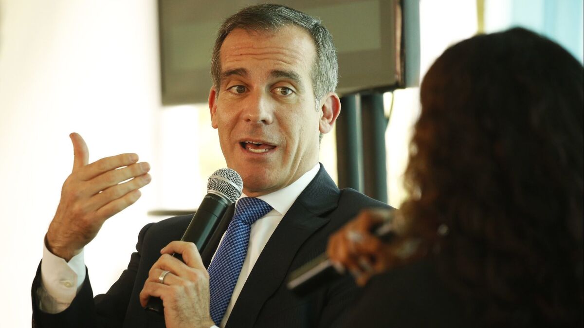 Los Angeles Mayor Eric Garcetti speaks with Rhiana Gunn-Wright, right, leader of a policy nonprofit called the New Consensus, just after Garcetti announced L.A.'s Green New Deal in Los Angeles on April 29.
