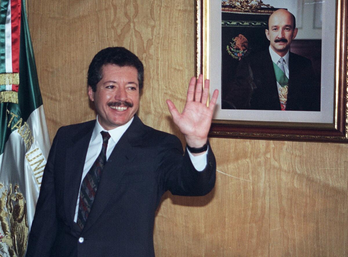 Luis Donaldo Colosio, flanqueado por una bandera nacional mexicana