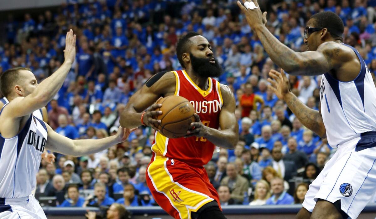 Rockets guard James Harden drives down the late against Mavericks guard J.J. Barea, left, and center Amar'e Stoudemire in the first half of their playoff game Friday night in Dallas.