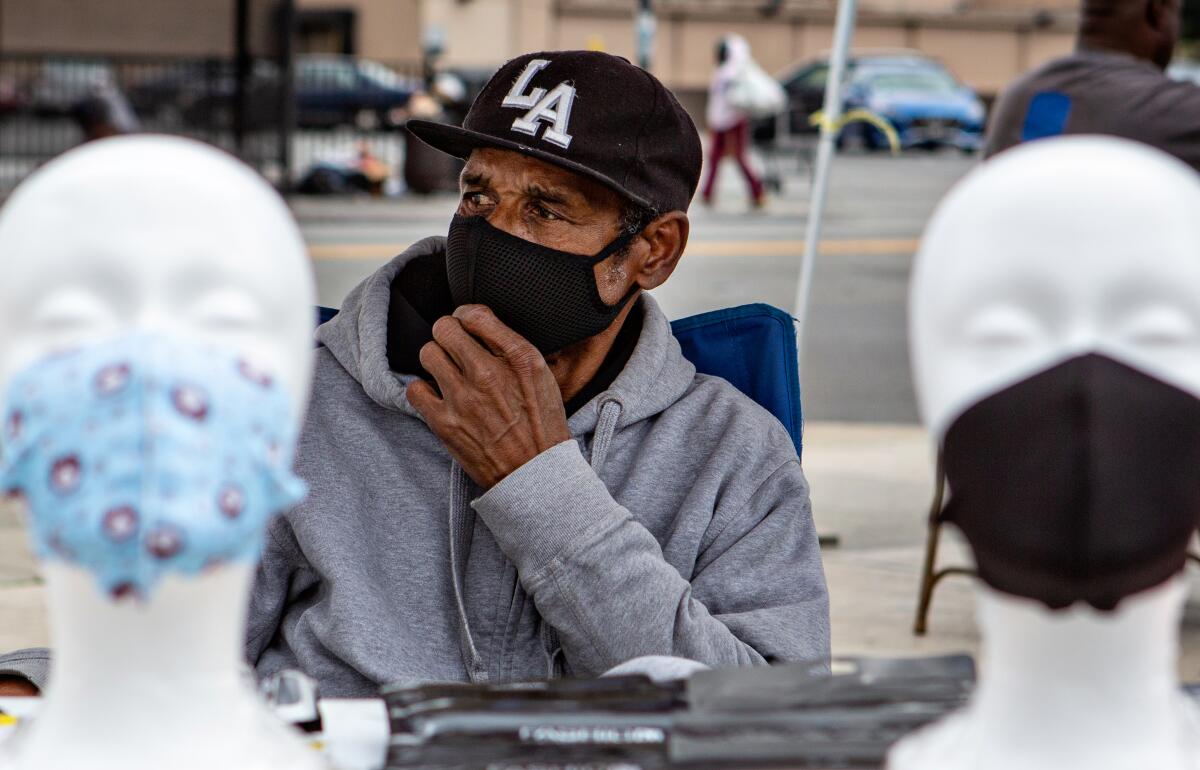 Larry Hickman of Los Angeles sells a variety of face mask on the corner of Western and Manchester Avenue in South Los Angeles