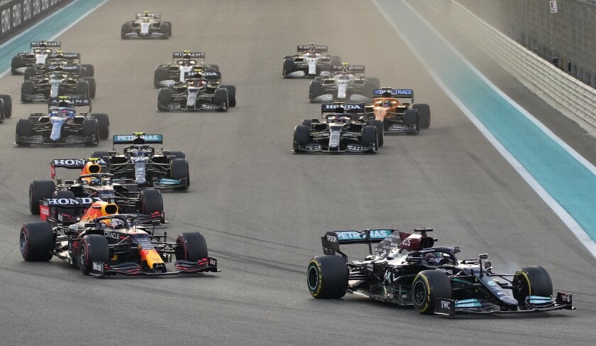 Mercedes driver Lewis Hamilton of Britain in leads Red Bull driver Max Verstappen of the Netherlands at the start of the Formula One Abu Dhabi Grand Prix in Abu Dhabi, United Arab Emirates, Sunday, Dec. 12. 2021. Max Verstappen ripped a record eighth title away from Lewis Hamilton with a pass on the final lap of the Abu Dhabi GP to close one of the most thrilling Formula One seasons in years as the first Dutch world champion. (AP Photo/Hassan Ammar)