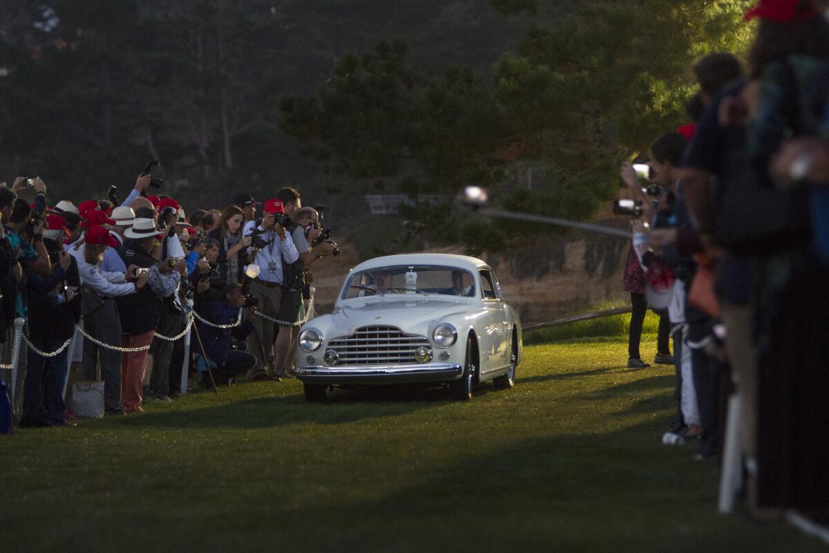 A 1950 Ferrari 195 INTER Ghia Coupe from Desselgem, Belgium, opens the pre-dawn parade of classic cars Sunday on the 18th green at the Lodge at Pebble Beach.