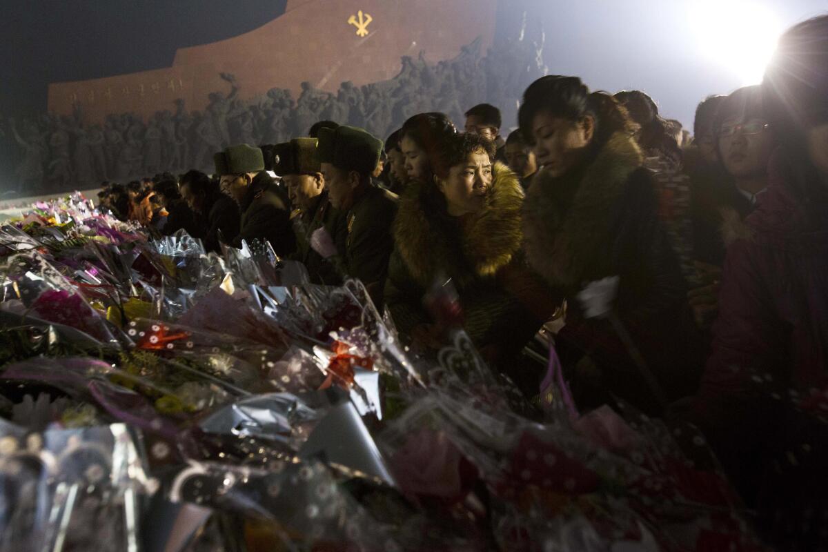 North Koreans lay flowers at the base of statues of the nation's founder, Kim Il Sung, and late leader Kim Jong Il in Pyongyang in December 2013 to commemorate the second anniversary of Kim Jong Il's death.