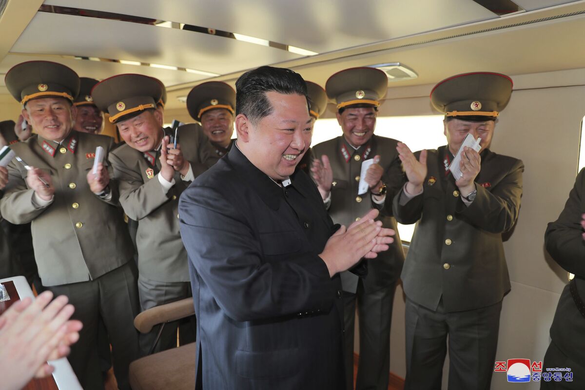Kim Jong Un and North Korean military leaders clap.