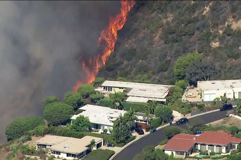 Los Angeles fire crews are responding to a roughly one-acre brush fire burning uphill near the 500 block of North Palisades Drive in Pacific Palisades.