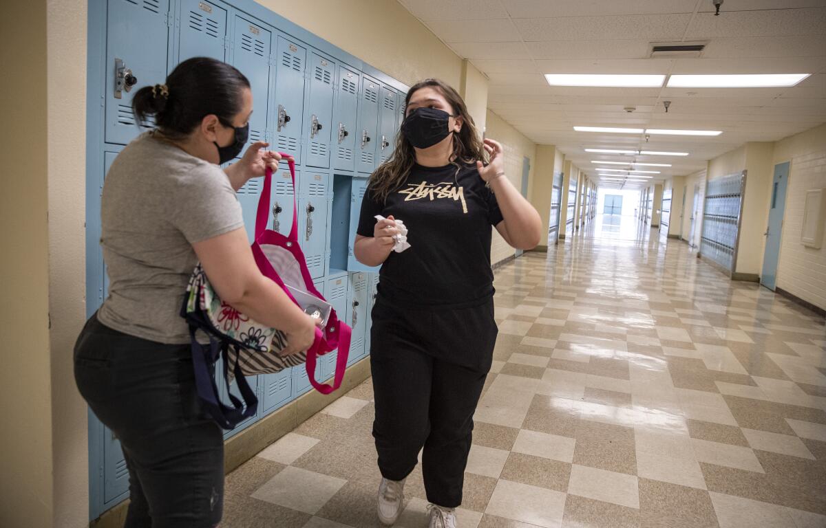 Jamie Zamudio, left, helps her daughter Isabella, 14, clean out her locker at El Camino Real Charter High School on April 30.