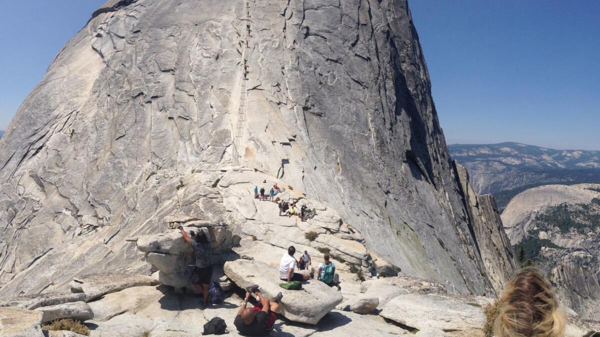 The day hike up Half Dome in Yosemite National Park covers 14 to 16 miles round-trip, with the last steep pitch lined with cables.