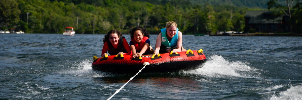 Three girls rafting in a lake.