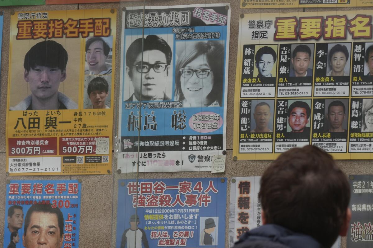 Un cartel de Satoshi Kirishima, centro, arriba, un fugitivo muy buscado por una serie de ataques