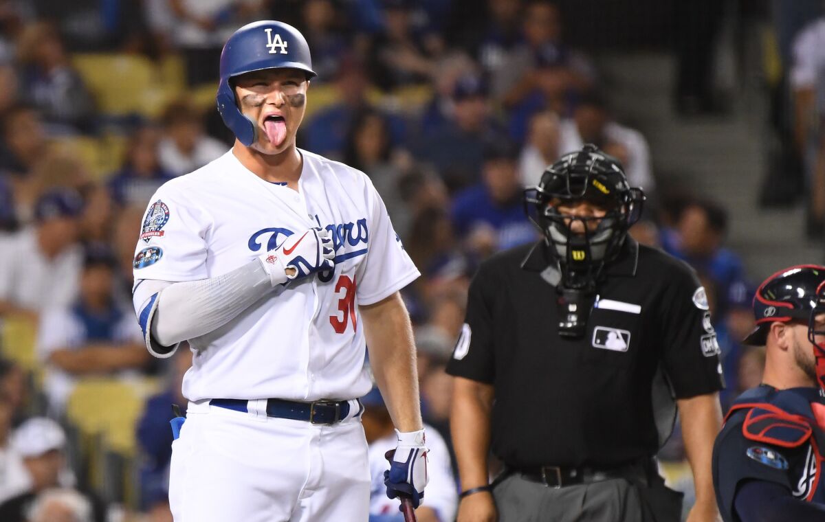 Dodgers Joc Pederson appears to have something caught in his throat as he walk out of the batters box against the Braves in the 7th inning on Thursday.