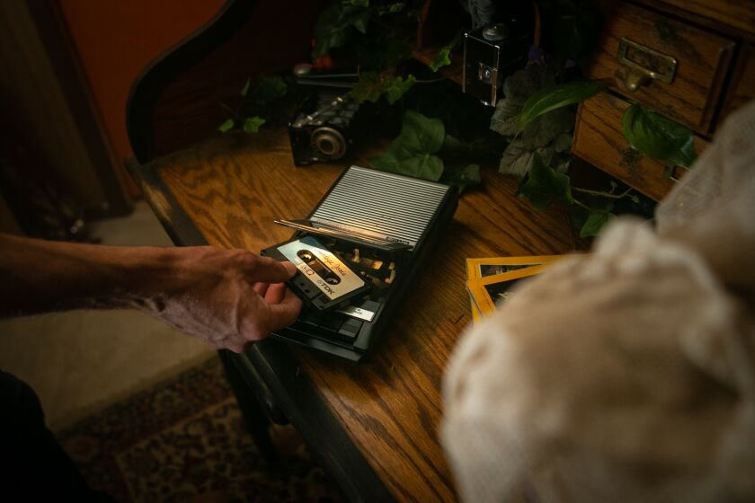 LOS ANGELES, CA - JUNE 29: Jarrett Lantz inserts a cassette into a tape player which is a key part of the "The Nest" a video game-like show in which two guests at a time try to uncover the history of a woman's life, learning about her hopes, dreams and failures on Tuesday, June 29, 2021 in Los Angeles, CA. (Jason Armond / Los Angeles Times)