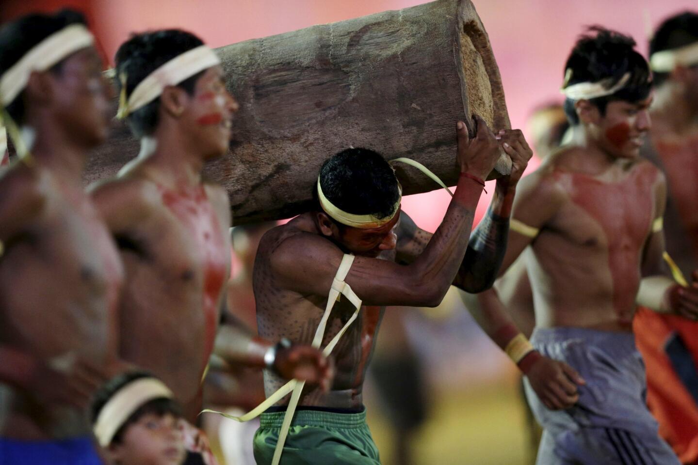 An indigenous man from the Xerente tribe competes in a relay race carrying a tree trunk during the first World Games for Indigenous Peoples in Palmas