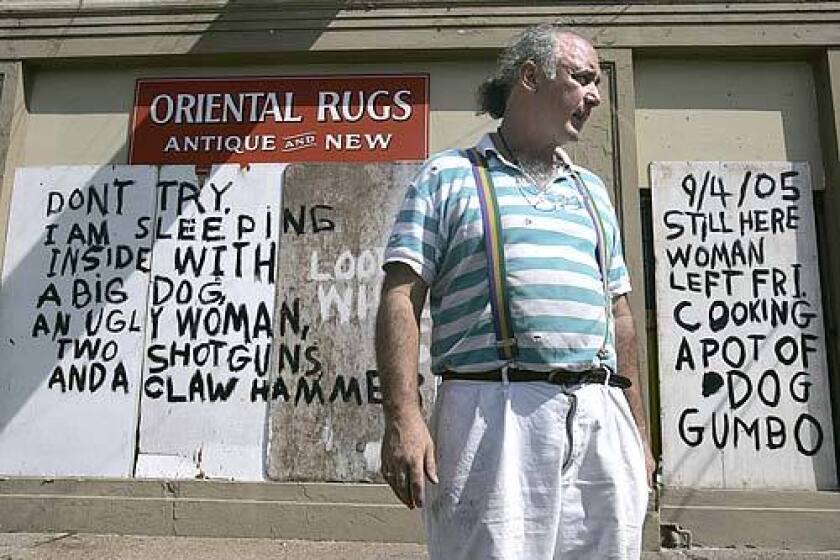 Bob Rue, owner of Oriental Rugs on St.Charles Ave in the Garden District of New Orleans, is hiding out in his shop, hoping authorities won't make him evacuate. The words on the front of his shop are meant to warn away looters.