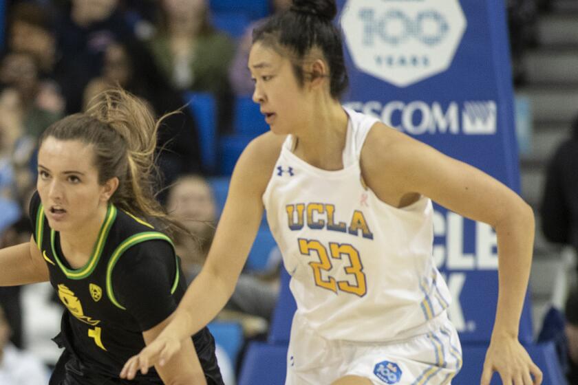 LOS ANGELES, CALIF. -- FRIDAY, FEBRUARY 14, 2020: Oregon Ducks guard Taylor Chavez (3), left, drives around UCLA Bruins guard Natalie Chou (23) during 4th quarter of Pac-12 basketball game at Pauley Pavilion in Los Angeles, Calif., on Feb. 14, 2020. (Brian van der Brug / Los Angeles Times)
