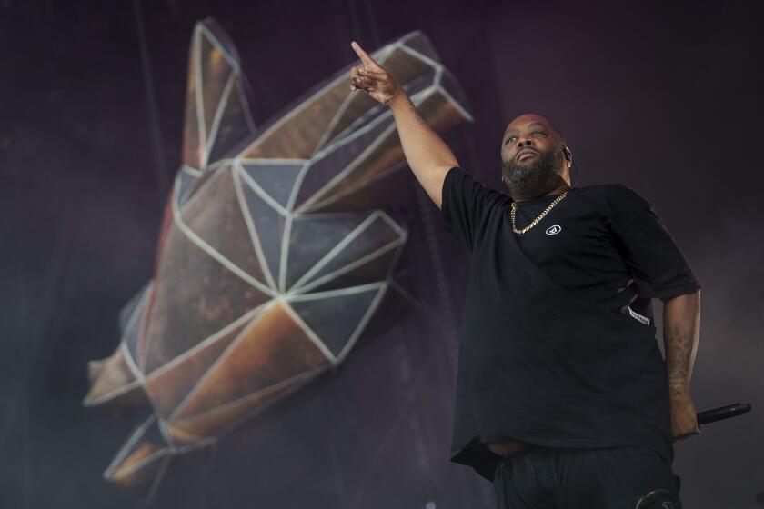 Killer Mike of Run the Jewels points his right index finger in the air while performing onstage