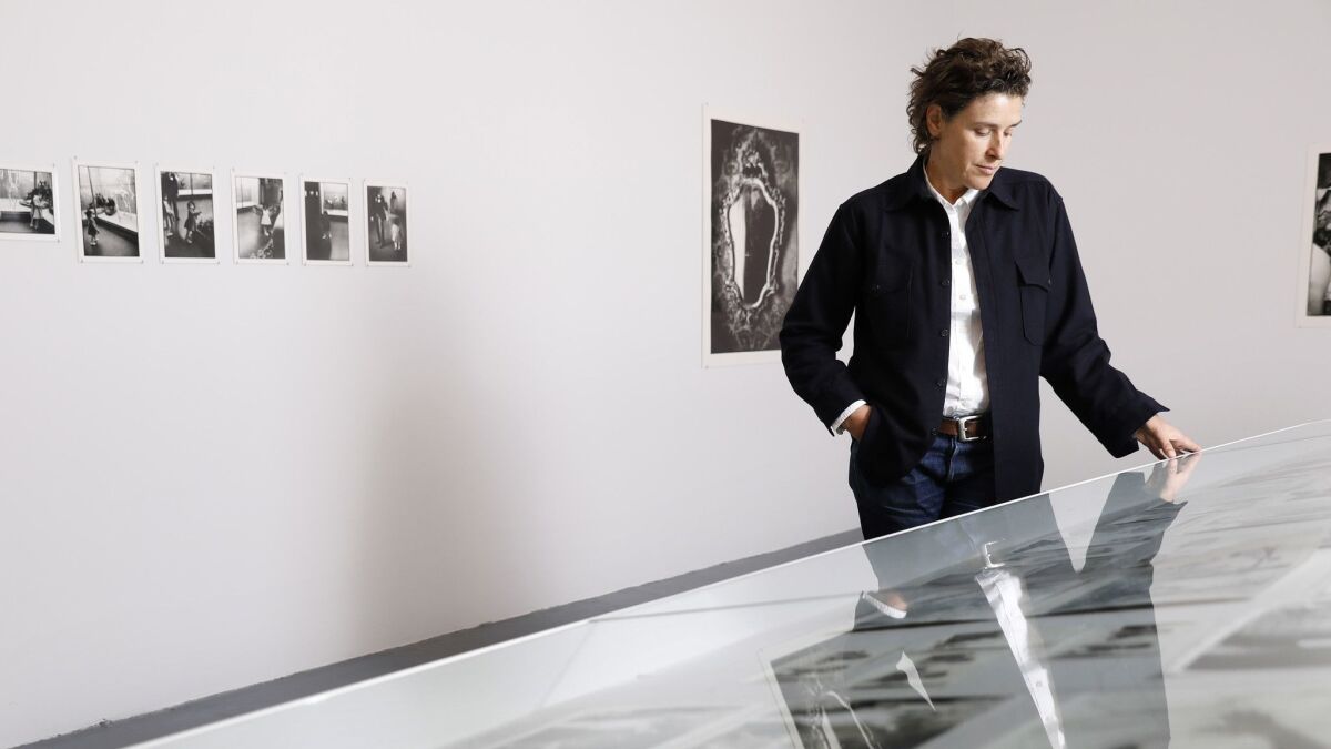 Zoe Leonard examines a vitrine containing her conceptual project, "The Fae Richard Photo Archive," at MOCA's Geffen Contemporary.
