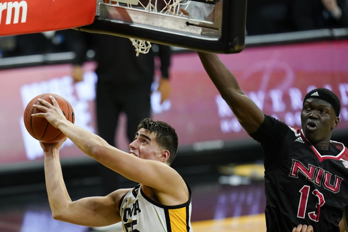 Iowa center Luka Garza drives to the basket past Northern Illinois center Adong Makuoi, right, during the first half of an NCAA college basketball game, Sunday, Dec. 13, 2020, in Iowa City, Iowa. (AP Photo/Charlie Neibergall)