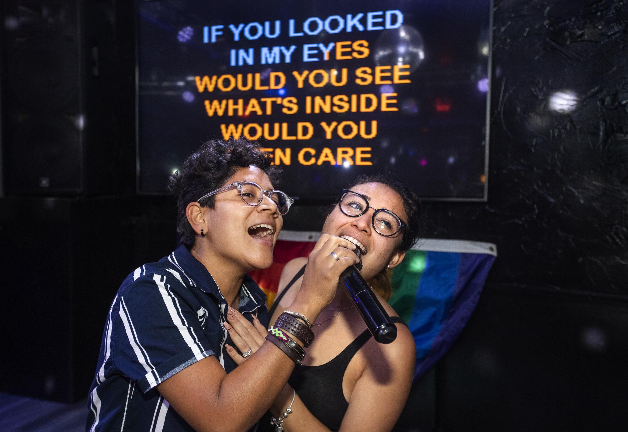 Two people performing karaoke. 