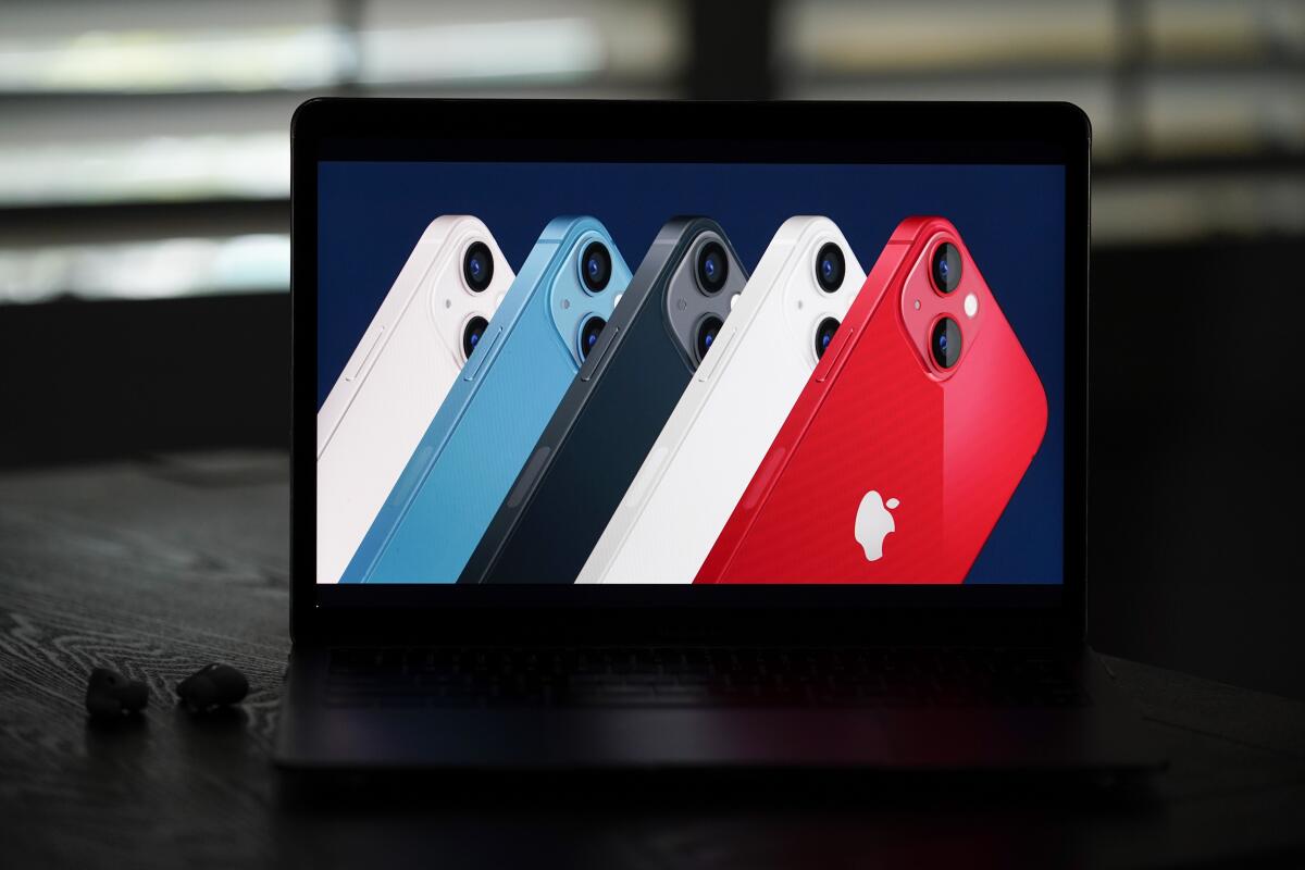 New iPhone 13 smartphones in different colors lined up on the screen of a mobile device.