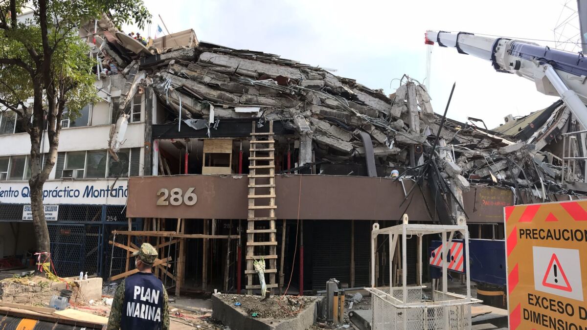 The upper stories at this office building at Avenida Alvaro Obregon 286 in Mexico City have collapsed, leaving entire floors stacked like pancakes. (Rong-Gong Lin II / Los Angeles Times)