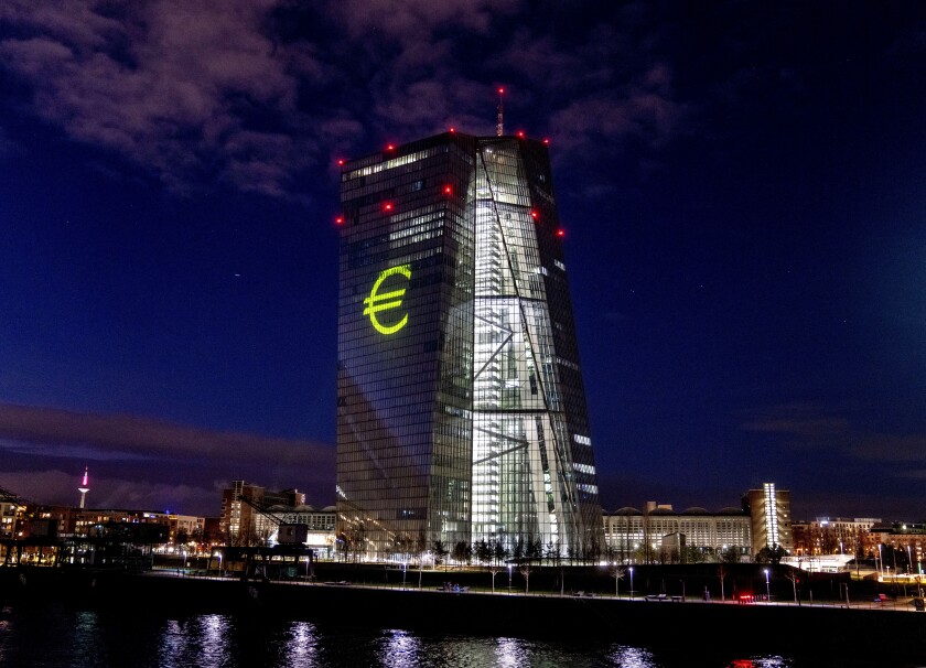 El símbolo del euro es proyectado en el edificio del Banco Central Europeo durante un ensayo en Fráncfort