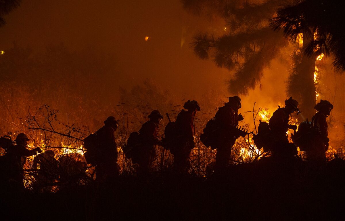 Firefighters head out for brush work in the Sepulveda Pass during the Getty fire