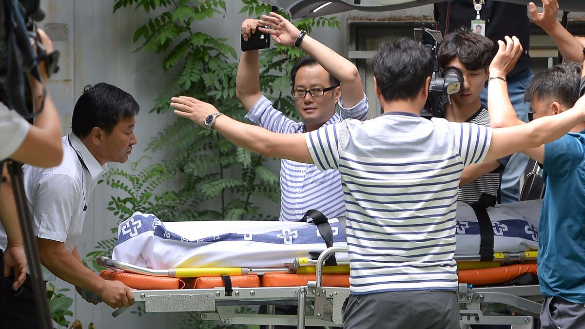 Hospital workers move the body of Lotte Group executive Lee In-won, who was found dead in Yangpyeong, South Korea, on Aug. 26.