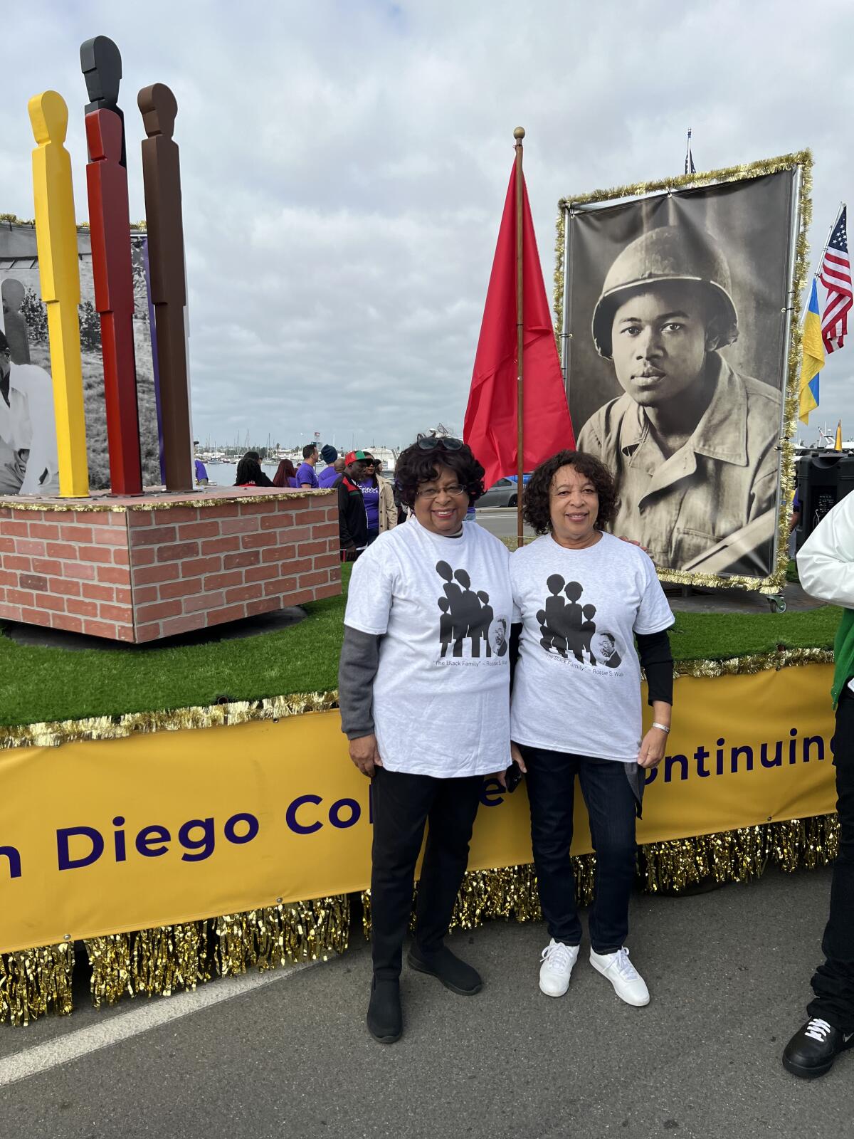Rossie Wade's daughters, Carole Boyce and Lynn Brown, left to right, stand in front of the float dedicated to their father