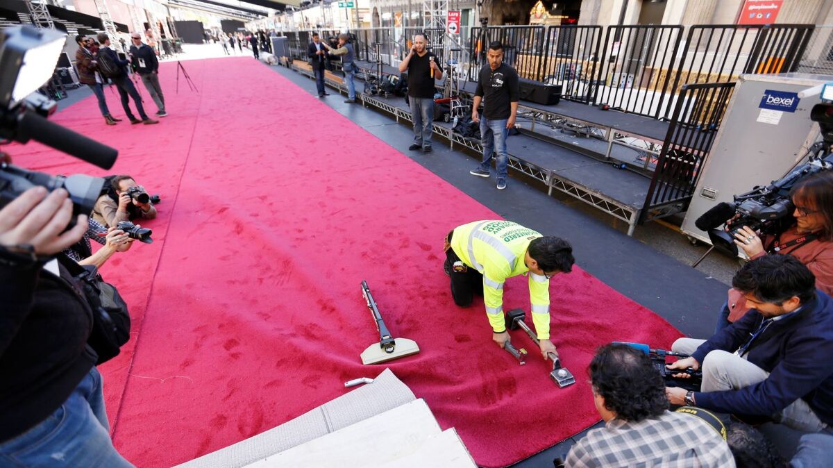 Carpet installer Rudy Morales positions the red carpet in front of the Dolby Theatre in Hollywood in advance of the 89th Academy Awards on Sunday.