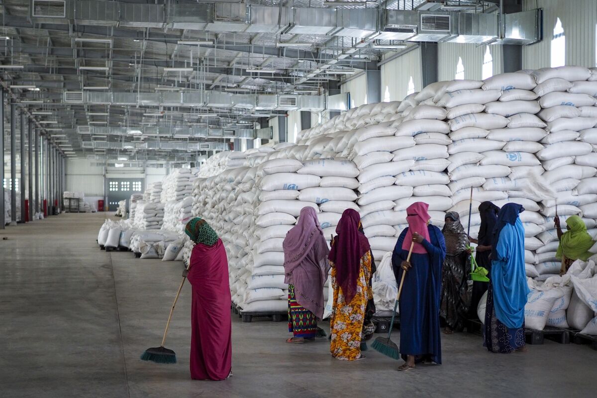 FILE - Workers clean the floor as sacks of food earmarked for the Tigray and Afar regions sits in piles in a warehouse of the World Food Programme (WFP) in Semera, the regional capital for the Afar region, in Ethiopia on Feb. 21, 2022. A convoy of trucks carrying food aid entered territory controlled by fighters loyal to the fugitive leaders of Ethiopia's Tigray region on Friday, April 1, 2022, the first humanitarian convoy to do so since Dec. 14, the United Nations World Food Program said. (AP Photo, File)
