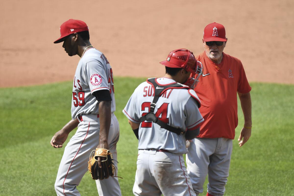 Angels relief pitcher Elvis Peguero is removed from the game by manager Joe Maddon in front of catcher Kurt Suzuki.