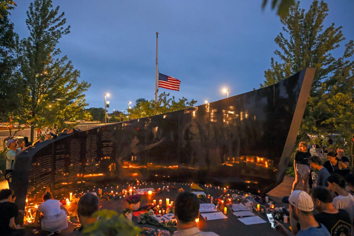 People hold candles at a vigil.