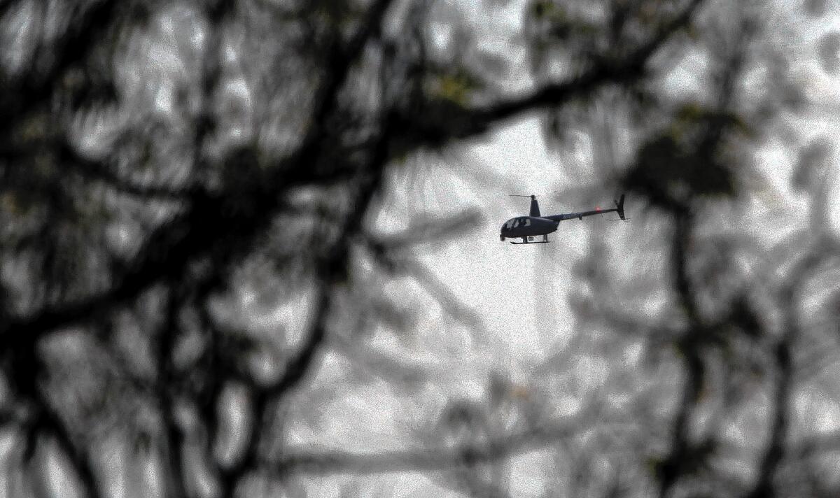 A helicopter flies over the Robinson Helicopter Co.'s headquarters in Torrance. Community groups have been trying to work with the firm to reduce noise around its plant.